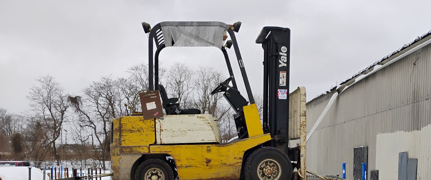 A forklift loaded on the flatbed deck in the snow