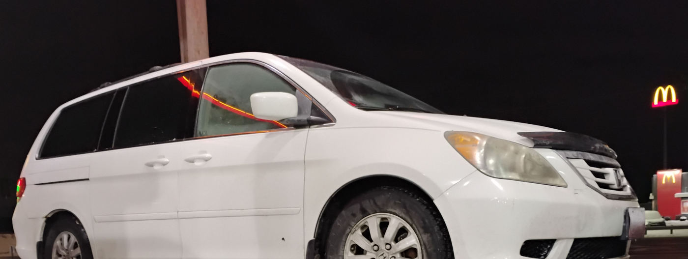 A minivan loaded on the flatbed at night